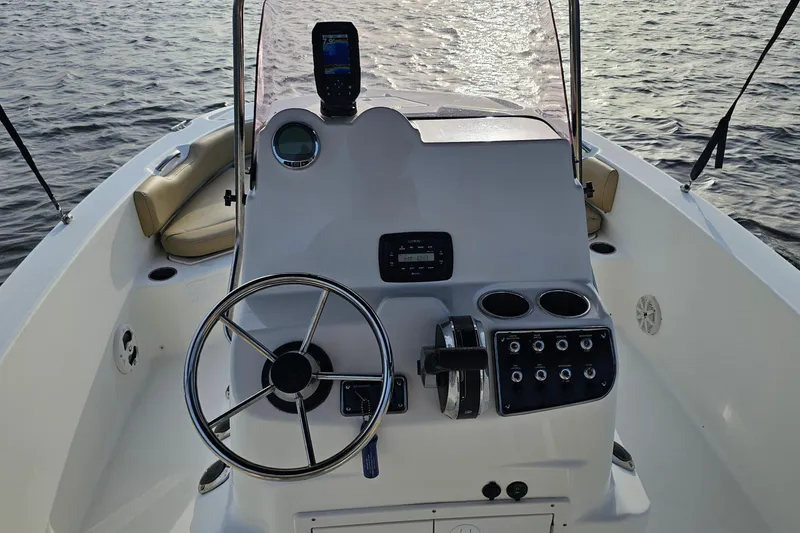 Slide: The Image of 2021 NauticStar 191 Hybrid boat console with steering wheel and controls on water. - 31