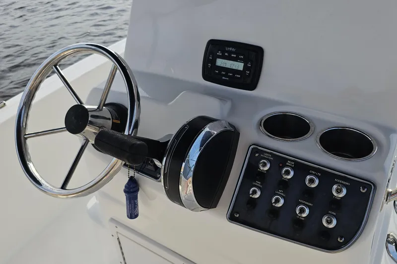 Slide: The Image of 2021 NauticStar 191 Hybrid boat console with steering wheel and control panel. - 32