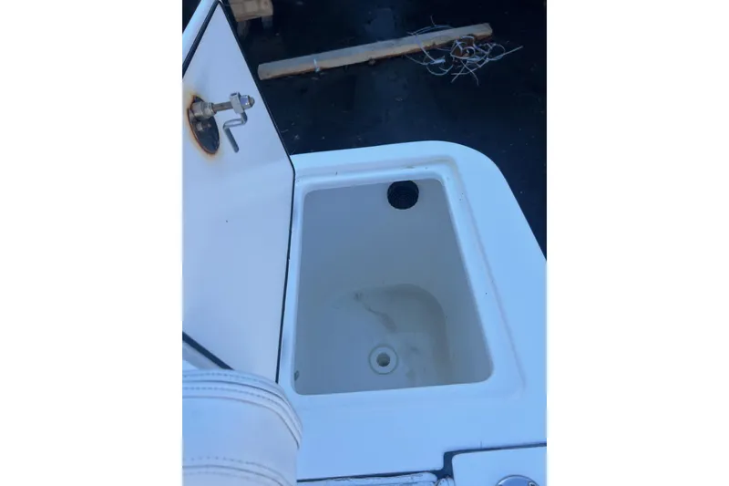 Slide: The Image of Open storage compartment on 2005 Edgewater 245CC boat, showing interior details. - 11