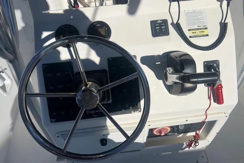 Slide: The Image of 2005 Edgewater 245CC boat dashboard with steering wheel and control panel. - 7