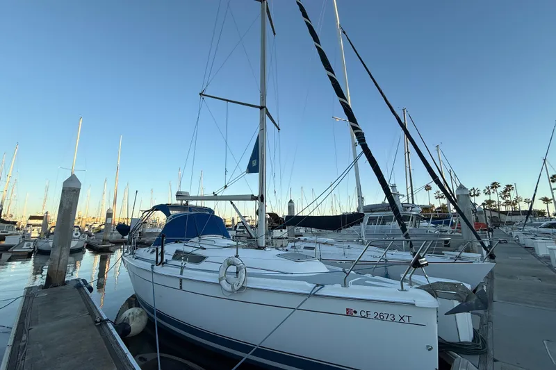 The Image of 2007 Hunter 31 sailboat docked in marina, clear sky, calm waters. - 0