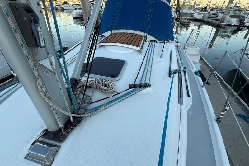 Slide: The Image of Sailboat deck of 2007 Hunter 31, featuring rigging and blue canopy in marina setting. - 12