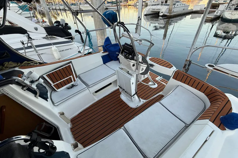 Slide: The Image of Cockpit of 2007 Hunter 31 sailboat with teak flooring and marina view. - 13