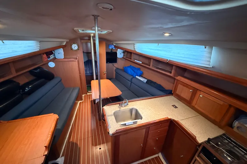 Slide: The Image of Interior of 2007 Hunter 31 sailboat with cozy seating, kitchen, and wooden cabinetry. - 19