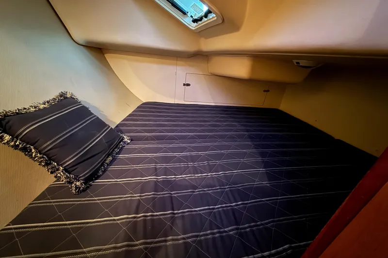 Slide: The Image of Cozy cabin interior of 2007 Hunter 31 sailboat with striped bedding and pillow. - 21