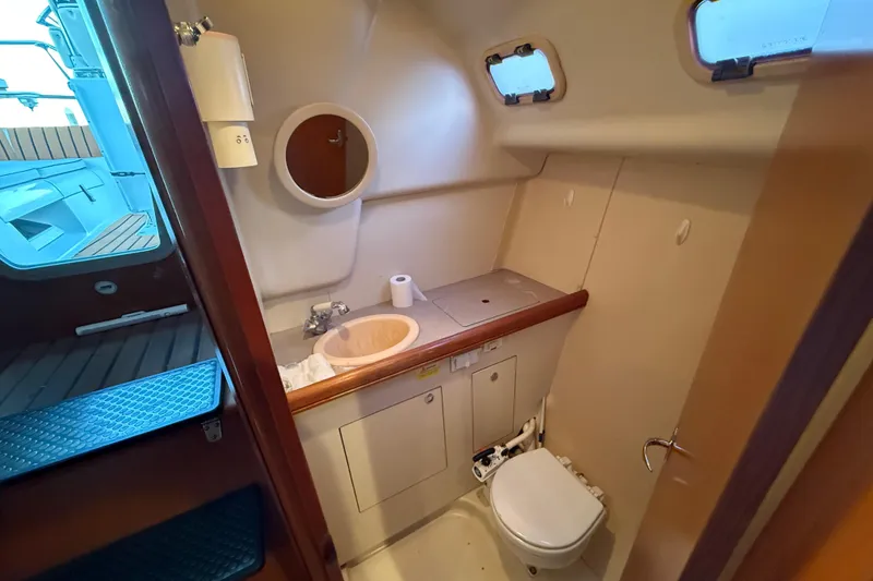 Slide: The Image of Compact bathroom in 2007 Hunter 31 sailboat with sink, toilet, and portholes. - 31