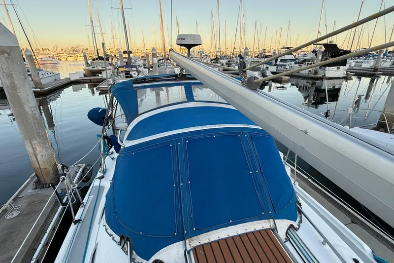 Slide: The Image of Hunter 31 sailboat, 2007 model, docked in a marina with blue canopy and wooden deck. - 9
