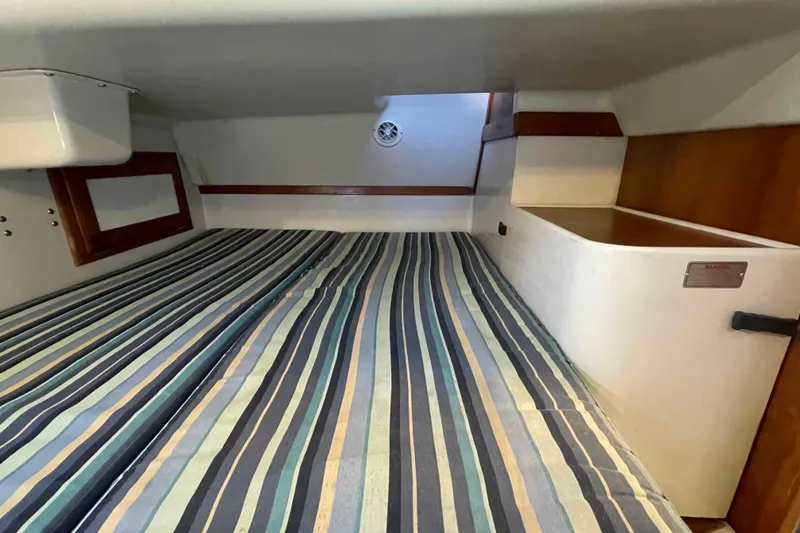 Slide: The Image of Interior cabin of 1995 Catalina 320 sailboat with striped bedding. - 108
