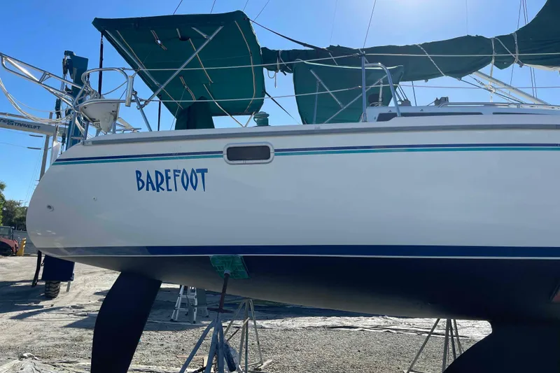 Slide: The Image of Cozy cabin interior of 1995 Catalina 320 sailboat with striped bedding and porthole window. - 13