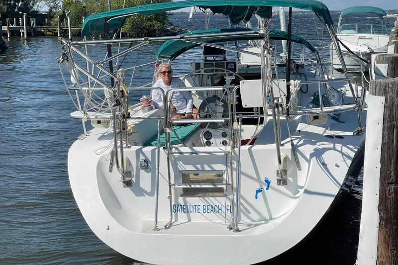 Slide: The Image of Catalina 320 yacht kitchen with dual sinks, stove, and wooden accents. - 23