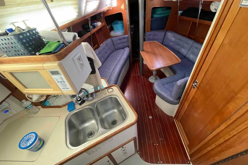 Slide: The Image of Engine compartment of a 1995 Catalina 320 sailboat, showing mechanical components and hoses. - 28