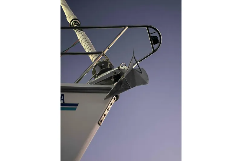 Slide: The Image of Person polishing a Catalina 320 sailboat hull under a clear blue sky. - 39