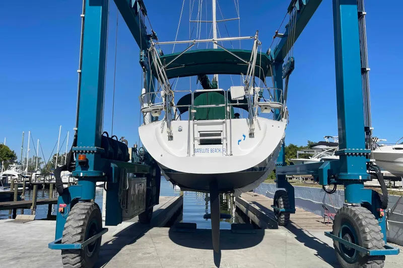 Slide: The Image of Catalina 320 sailboat with green canopy, docked under a clear blue sky. - 42