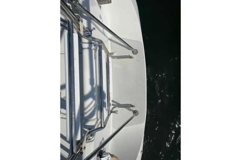 Slide: The Image of Catalina 320 sailboat docked with green covers, named "Barefoot." - 51