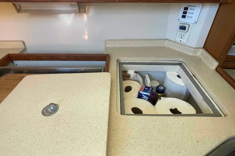 Slide: The Image of 1995 Catalina 320 sailboat cockpit with winches and rope storage, docked at marina. - 76