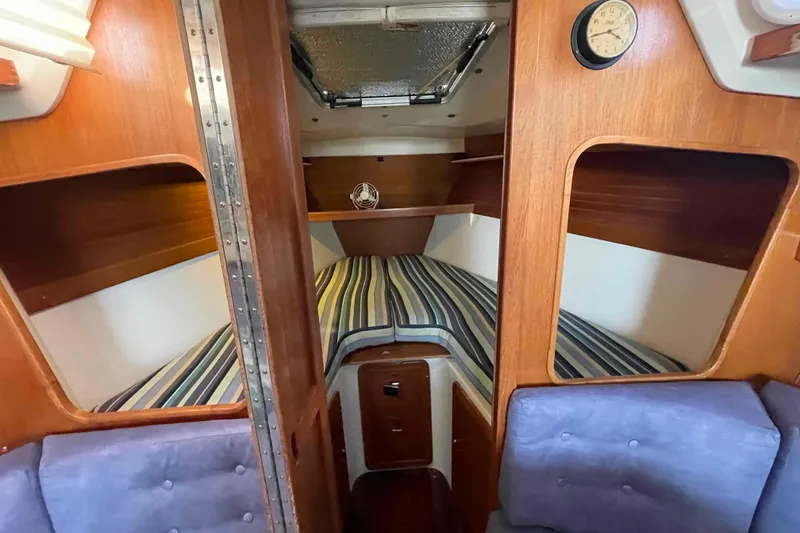 Slide: The Image of Catalina 320 sailboat cockpit with teal cushions and wooden hatch, docked at marina. - 78