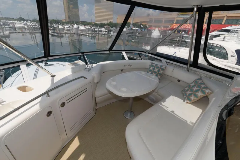 Slide: The Image of 2004 Sea Ray 480 Sedan Bridge yacht interior with white seating and marina view. - 10