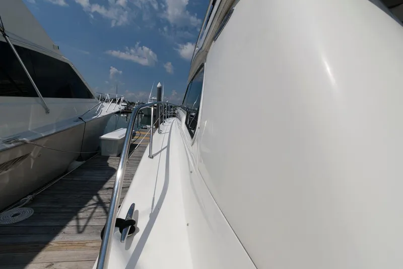 Slide: The Image of 2004 Sea Ray 480 Sedan Bridge yacht docked under a clear blue sky. - 14