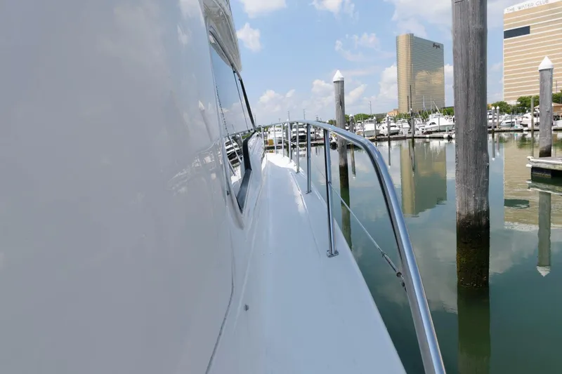 Slide: The Image of 2004 Sea Ray 480 Sedan Bridge yacht docked in marina, clear sky, calm water. - 15