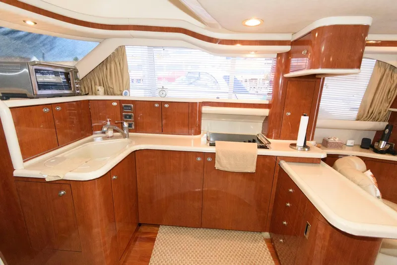 Slide: The Image of Luxurious kitchen interior of 2004 Sea Ray 480 Sedan Bridge yacht with wooden cabinetry. - 21