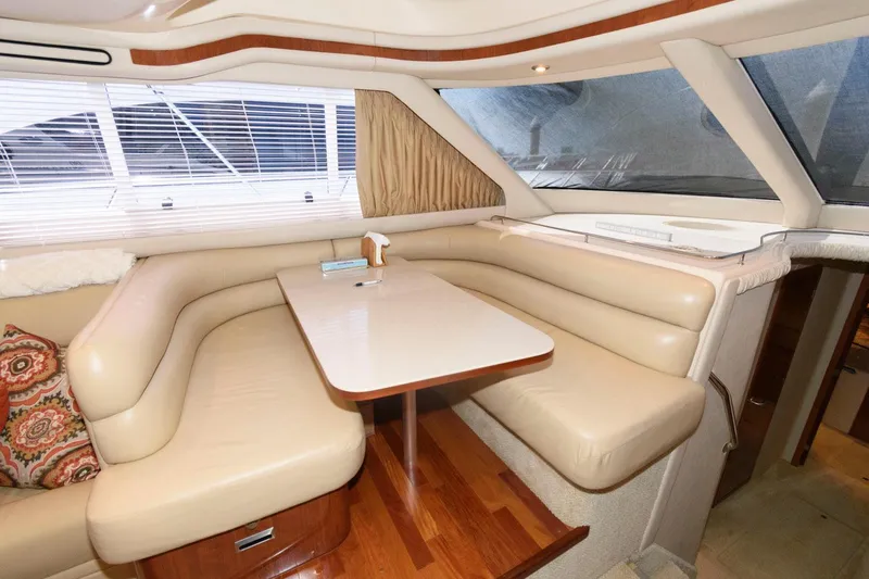 Slide: The Image of Luxurious 2004 Sea Ray 480 Sedan Bridge interior with beige leather seating and wooden accents. - 22