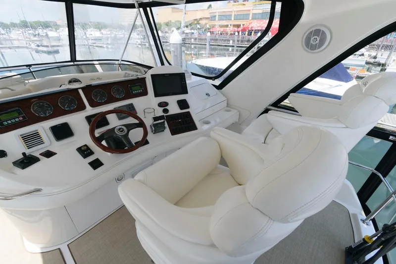 Slide: The Image of 2004 Sea Ray 480 Sedan Bridge helm with white leather seats and modern controls. - 5