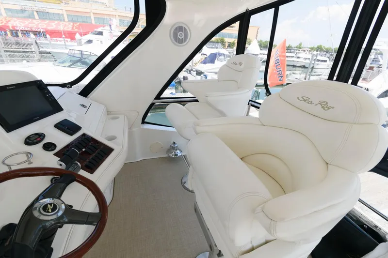 Slide: The Image of 2004 Sea Ray 480 Sedan Bridge interior with white leather seats and control panel. - 6