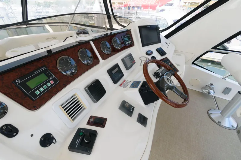 Slide: The Image of Control panel of a 2004 Sea Ray 480 Sedan Bridge yacht, featuring gauges and steering wheel. - 8