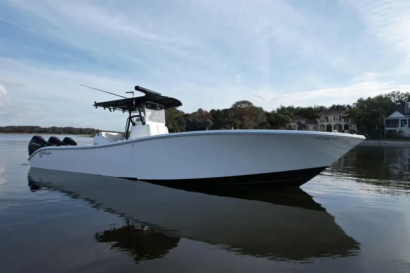 Slide: The Image of 2009 Yellowfin 36 Offshore boat on calm water, with scenic background. - 14