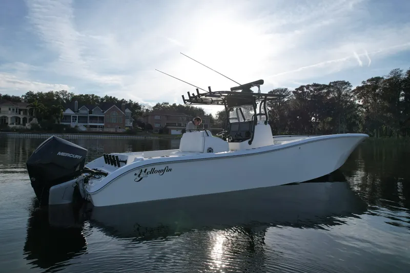Slide: The Image of 2009 Yellowfin 36 Offshore boat on calm water, with Mercury engines, under a clear sky. - 2
