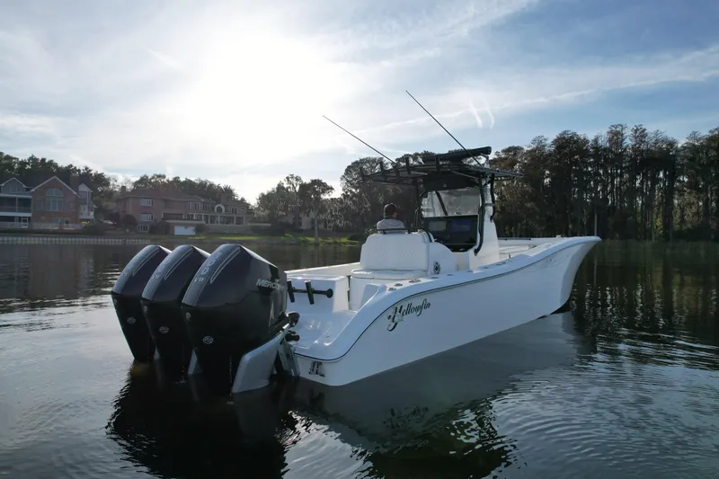 Slide: The Image of 2009 Yellowfin 36 Offshore boat on calm water, with triple Mercury engines. - 4
