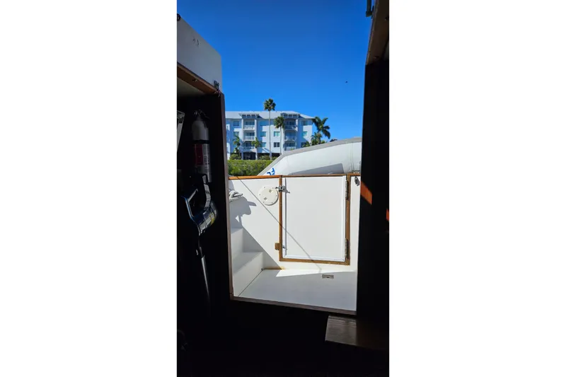 Slide: The Image of 1984 Albin Palm Beach 37 boat interior view with open door, blue sky background. - 28