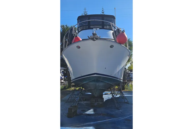 Slide: The Image of 1984 Albin Palm Beach 37 boat on dry dock with red fenders, viewed from front. - 3