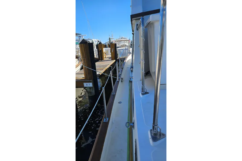 Slide: The Image of 1984 Albin Palm Beach 37 yacht docked at marina, side view with clear blue sky. - 8