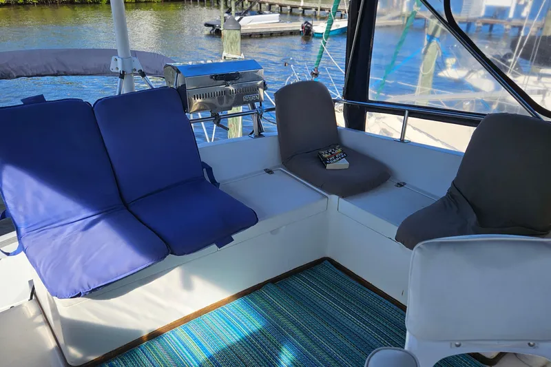 Slide: The Image of Cozy seating area on 1984 Albin Palm Beach 37 yacht with blue cushions and a book. - 22