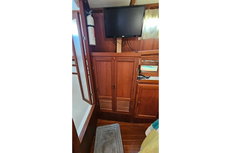 Slide: The Image of 1984 Albin Palm Beach 37 interior with wooden cabinets, mounted TV, and fire extinguisher. - 58