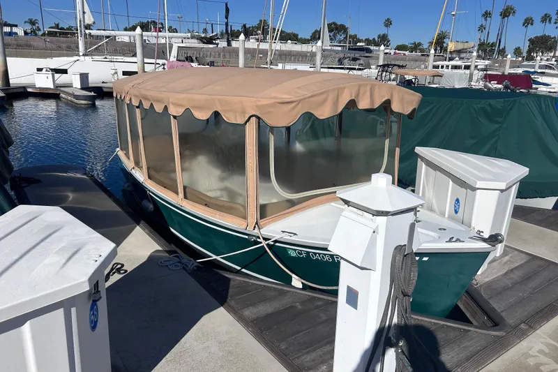 The Image of 2005 Duffy Classic 21 electric boat docked in marina with tan canopy. - 1