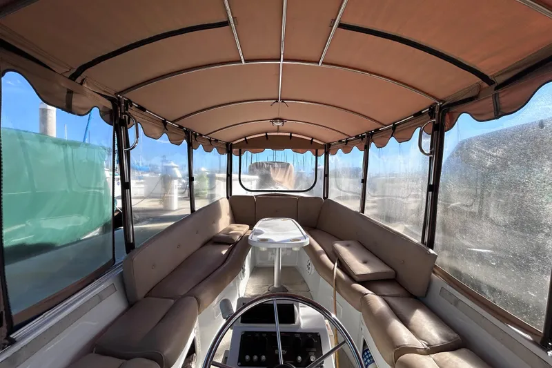 Slide: The Image of Interior of a 2005 Duffy Classic 21 boat with beige seating and canopy. - 3