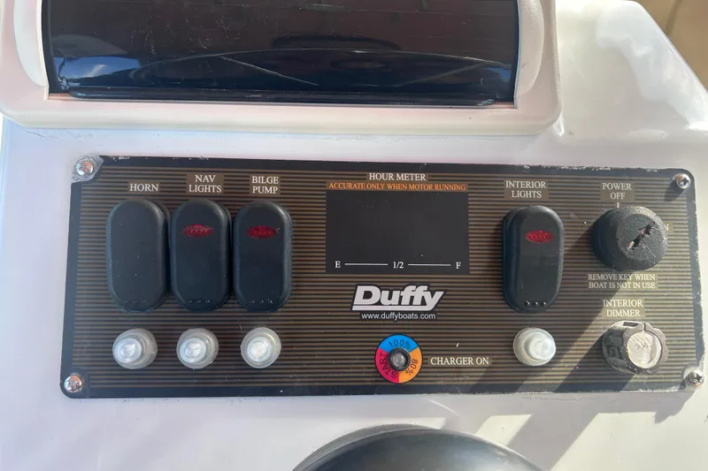 Slide: The Image of Control panel of a 2005 Duffy Classic 21 boat with various switches and hour meter. - 4
