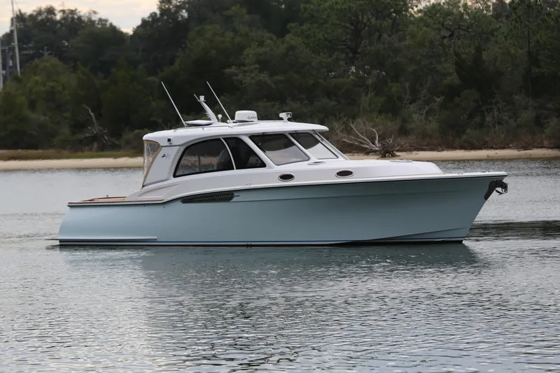 The Image of 2014 San Juan 41 boat on calm water, surrounded by trees. - 1