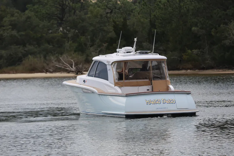 Slide: The Image of 2014 San Juan 41 boat named "Mango Tango" cruising on a calm waterway. - 3