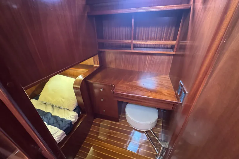 Slide: The Image of 2014 San Juan 41 yacht interior with wooden desk, shelves, and cozy sleeping area. - 41