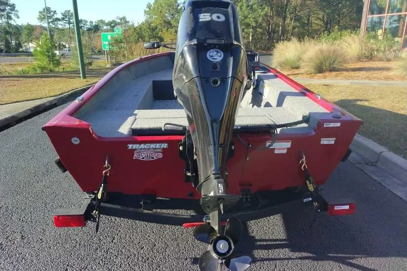 Slide: The Image of 2026 Tracker Super Guide V-16 SC boat with outboard motor, parked on asphalt. - 3