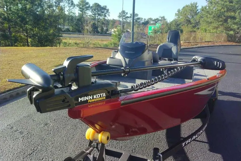 Slide: The Image of 2026 Tracker Super Guide V-16 SC boat with Minn Kota PowerDrive motor on a sunny day. - 6