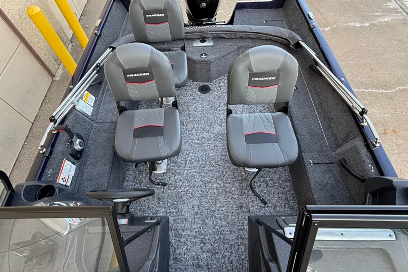 Slide: The Image of 2026 Tracker Pro Guide V-16 WT boat interior with two gray seats and steering console. - 49