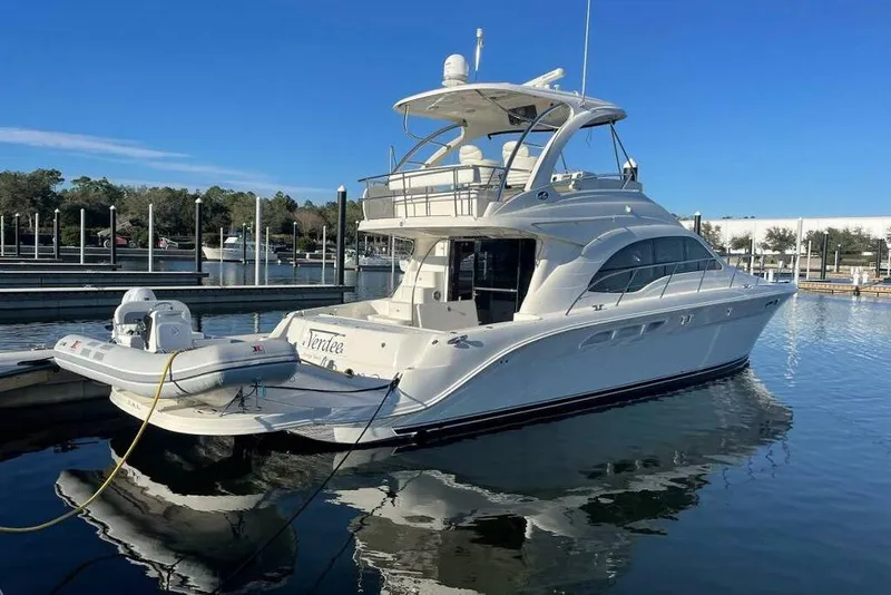 The Image of 2007 Sea Ray 52 Sedan Bridge yacht docked at marina under clear blue sky. - 0