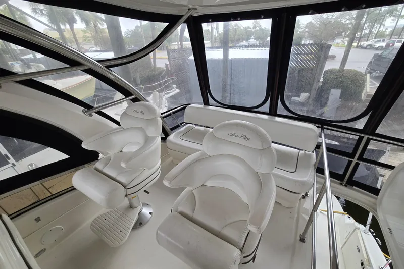 Slide: The Image of 2007 Sea Ray 52 Sedan Bridge helm with white seating and control panel. - 11