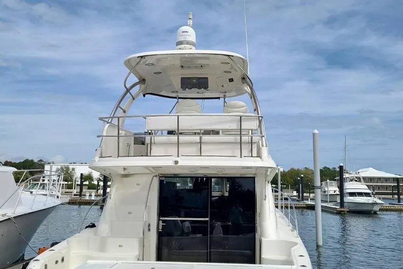 Slide: The Image of 2007 Sea Ray 52 Sedan Bridge yacht docked at marina under clear blue sky. - 2