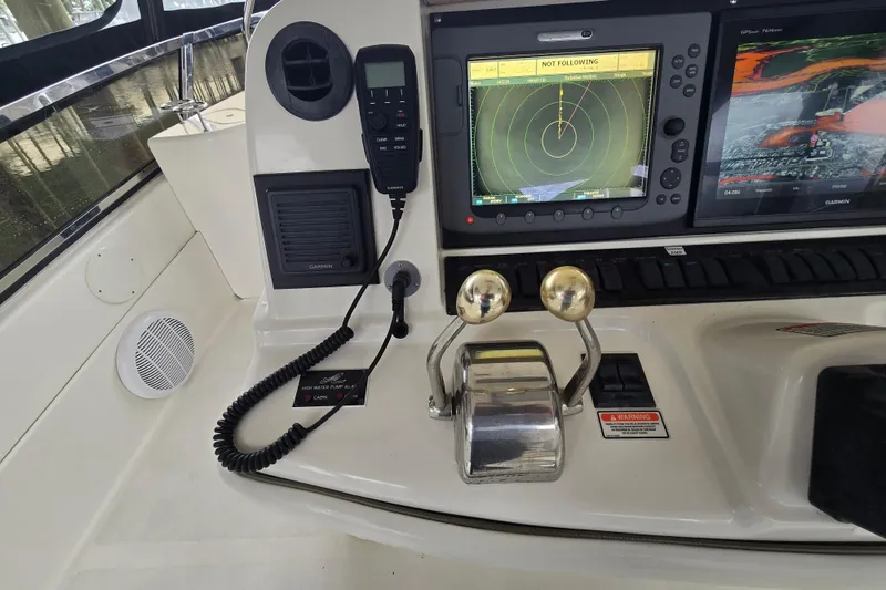 Slide: The Image of 2007 Sea Ray 52 Sedan Bridge helm with navigation screens and wooden steering wheel. - 20
