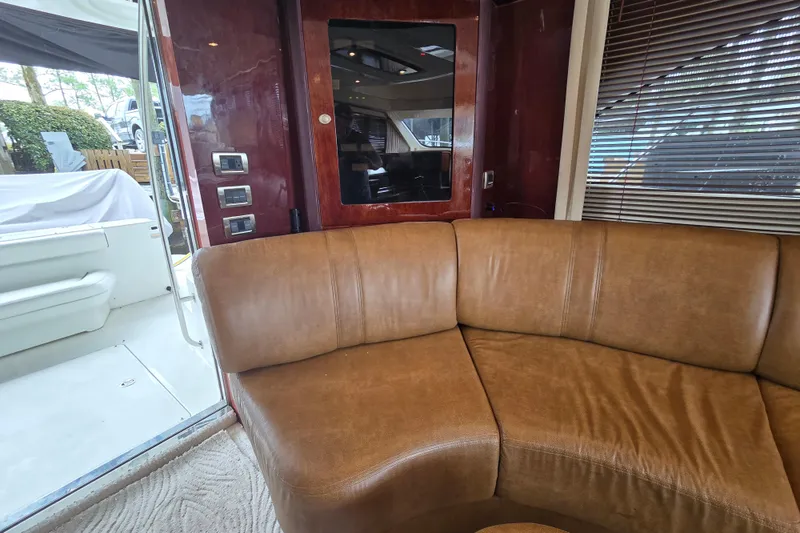 Slide: The Image of Interior of 2007 Sea Ray 52 Sedan Bridge with TV, brown sofa, and glass door. - 27